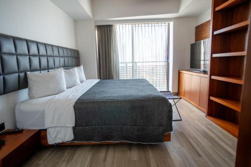 Ένα ή περισσότερα κρεβάτια σε δωμάτιο στο Sonata Hotel Puebla Angelópolis Distrito Sonata