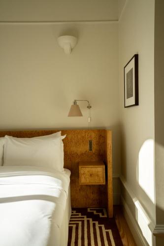a bedroom with a white bed and a lamp at Stockholm Stadshotell in Stockholm