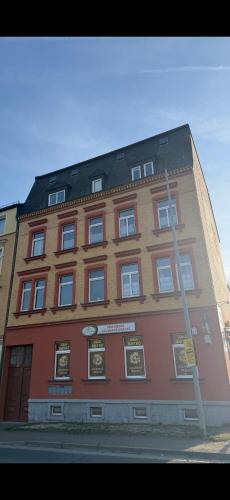 a large red building with a lot of pictures on it at Ferienwohnung Goldener Drache in Adorf