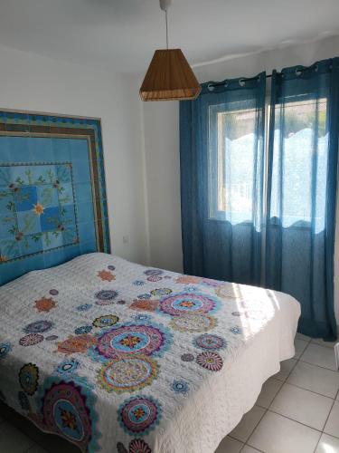 une chambre avec un lit avec une couette dessus dans l'établissement Les Jardins d’Alzetu, à Porto-Vecchio