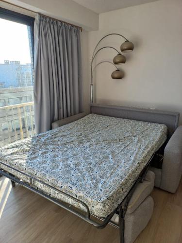 a table with a bed in a room with a window at Appartement vue mer in Koksijde