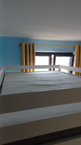 an empty bed in a room with a window at Appartement vue mer in Koksijde