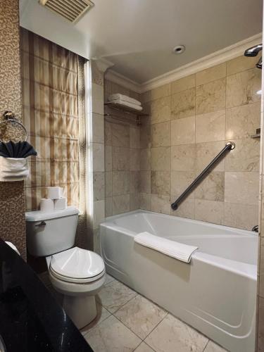 a bathroom with a white tub and a toilet at Executive Penthouse Suite, Downtown Vancouver in Vancouver