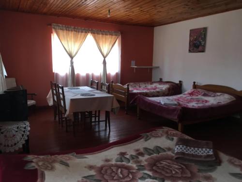 a room with two beds and a table and chairs at Antsaly in Antananarivo