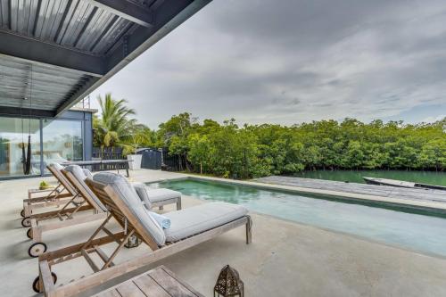 an outdoor patio with lounge chairs and a swimming pool at Casa Balam in Placencia Village