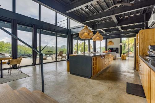 an open kitchen with large windows and a dining area at Casa Balam in Placencia Village