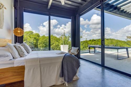 a bedroom with a bed and a large window at Casa Balam in Placencia Village