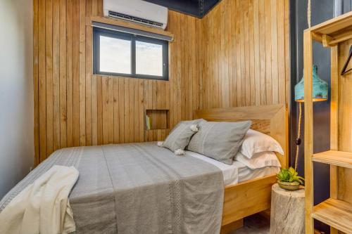 a bedroom with a bed in a wooden room at Casa Balam in Placencia Village