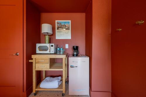 a small kitchen with a refrigerator and a microwave at Monaco Vacation Rentals in Clearwater Beach