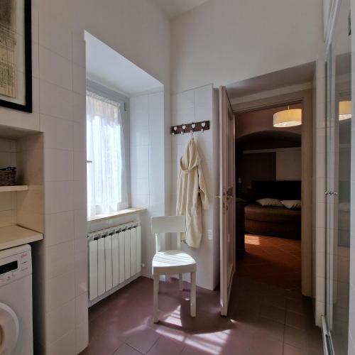 a bathroom with a white chair and a bedroom at Il Cortile di San Rufino in Assisi