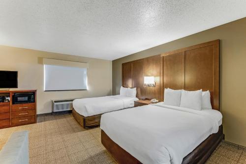 a hotel room with two beds and a flat screen tv at Comfort Suites Huntsville MidCity District at Research Park in Huntsville