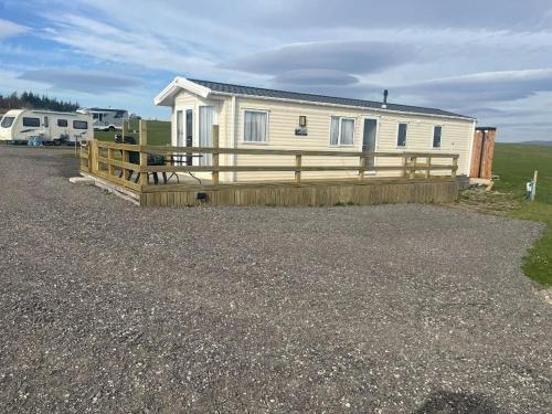 Casa móvil con valla y remolque en Woodend Caravan, en Shinness