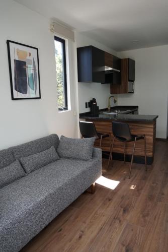 a living room with a couch and a kitchen at Container Woods in Valle de Bravo
