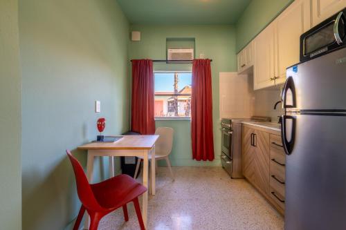 a kitchen with a table and red chairs and a refrigerator at Monaco Vacation Rentals in Clearwater Beach