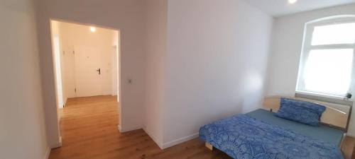 a bedroom with a blue bed and a window at New flat for 7 Special price per month 4 Rooms in Zeitz