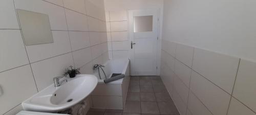 a white bathroom with a toilet and a sink at New flat for 7 Special price per month 4 Rooms in Zeitz