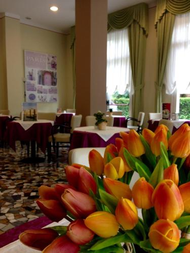 a bunch of flowers in a room with tables at Terme Villa Pace in Abano Terme