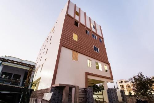 un edificio alto blanco con techo marrón en Super Hotel O CJ Inn, en Vijayawada