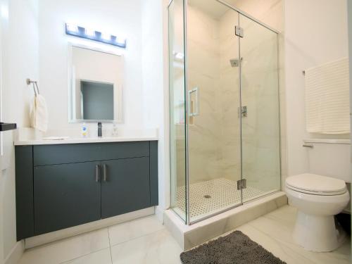 a bathroom with a glass shower and a toilet at Stylish and Modern 2 - Bedroom apt minutes from NYC! in Bayonne