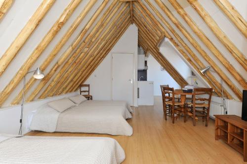 1 Schlafzimmer mit 2 Betten, einem Tisch und Stühlen in der Unterkunft Hotel - Cafe De Harmonie in Edam