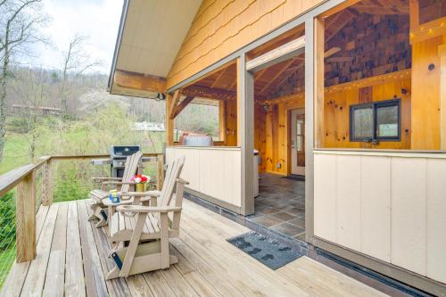 a porch of a wooden house with a table and chairs at Sawyers Cabin with Hot Tub in Blue Ridge Mtns! in Fletcher