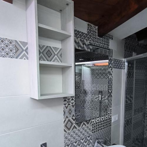 a bathroom with a shower and a wall with tiles at B&B Vicolo50 Salerno in Salerno
