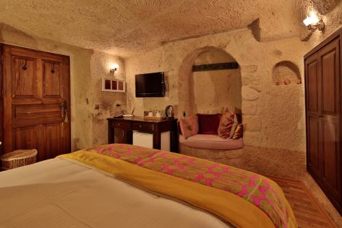 a bedroom with a bed and a sink in a room at Elaa Cave Hotel in Ortahisar