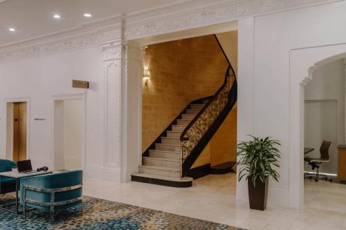 a lobby with a staircase in a building at Club Quarters Hotel Downtown, Houston in Houston
