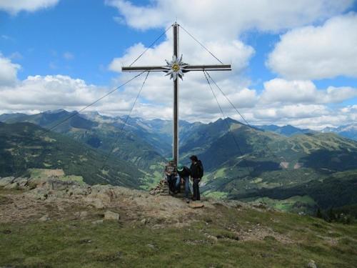 a man standing next to a cross on a mountain at Pension Waldhauser in Rennweg