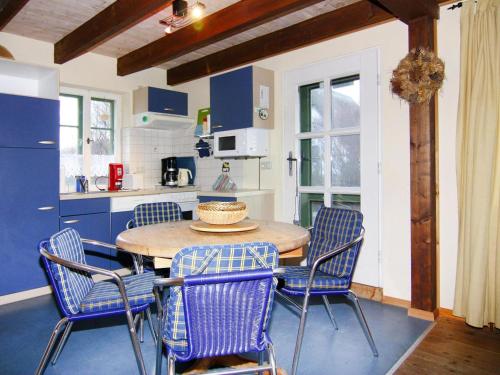 a kitchen with a wooden table and blue chairs at Reihenhäuser im Hafendorf Vieregge auf Rügen in Vieregge