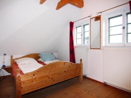a bedroom with a wooden bed and a window at Reihenhäuser im Hafendorf Vieregge auf Rügen in Vieregge