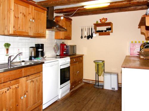 a kitchen with white appliances and wooden cabinets at Reihenhäuser im Hafendorf Vieregge auf Rügen in Vieregge