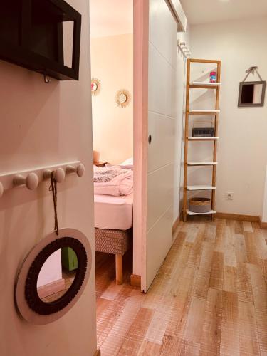 a small room with a bed and a door with a mirror at Home St. Germain in Trouville-sur-Mer
