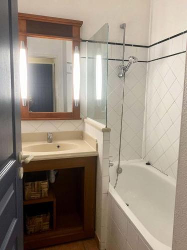 une salle de bain avec un lavabo, une baignoire et un miroir dans l'établissement Résidence Lacanau Les Pins - 01416_ Appartement T2 avec balcon dans résidence avec piscine collective chauffée MAE-0841, à Lacanau