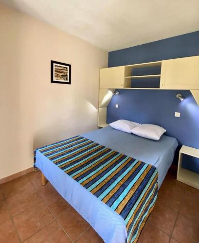 - un lit bleu avec deux oreillers dans une chambre dans l'établissement Résidence Lacanau Les Pins - 01416_ Appartement T2 avec balcon dans résidence avec piscine collective chauffée MAE-0841, à Lacanau