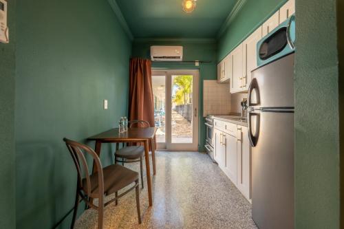 a kitchen with green walls and a table and a refrigerator at Monaco Vacation Rentals in Clearwater Beach