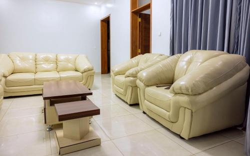 two couches and a table in a living room at UMUCYO House in Kigali