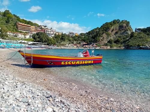 a boat sitting on the shore of a beach at Casa Basilico' Taormina in Taormina