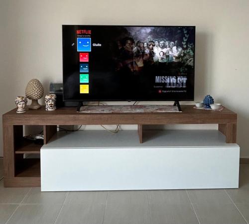 a flat screen tv sitting on top of a white stand at Le Terrazze della Dolce Casa - Blue Wave - Casa Vacanza a Marina di Ragusa in Marina di Ragusa