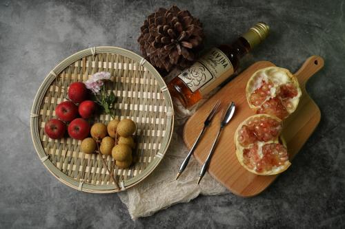 a table with two baskets of fruit and a bottle of wine at Vila Ravijojla in Kravlja