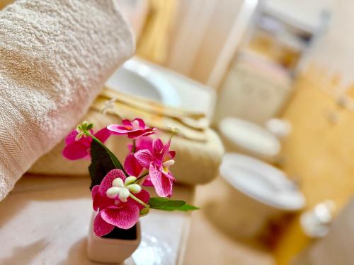 a vase filled with flowers sitting on a bathroom counter at Villa Sant Anna in Alghero