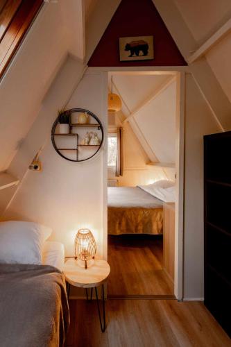 a small room with a bed and a table with a lamp at Het Hertenbos Chalet 136 - Bos- Groene Oase- Rustmoment- Zwembad in Durbuy