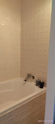 Un baño con bañera y lavabo. en Maison complete avec 5 chambres, en Montauban