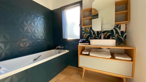 une salle de bain avec une baignoire et un lavabo dans l'établissement Villa des Pins, à Andernos-les-Bains