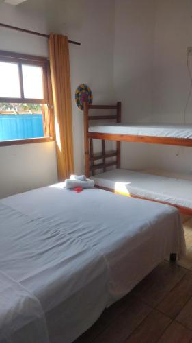a bedroom with two bunk beds and a window at Hostel Canto da Alegria in Itanhaém