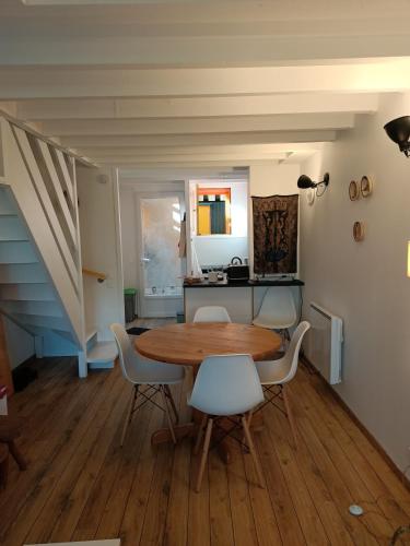 une salle à manger avec une table et des chaises en bois dans l'établissement Charmant triplex avec jardin, proche des plages, à Lège-Cap-Ferret