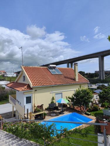 a house with a swimming pool in front of it at Casa Maria in Loures