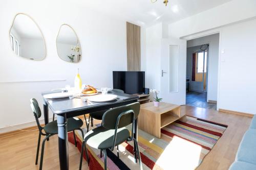 un salon avec une table et des chaises de salle à manger dans l'établissement Très bel appartement Mulhouse Parking gratuit, à Mulhouse