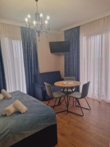 a bedroom with a bed and a table and chairs at Lake House in Tskaltubo