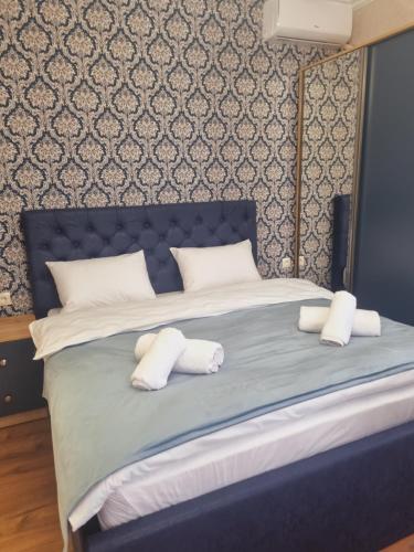 a blue bed with white pillows on top of it at Lake House in Tskaltubo